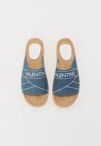 Denimové šľapky na slip-on s bielym prešívaním a tkanými jute podrážkami. Majú pohodlný dizajn s otvorenou špičkou a logom značky na stielkach.
