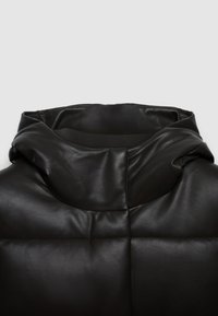 Veste en cuir noir avec une capuche douce et rembourrée. Présente une texture lisse, une coupe décontractée et des détails de couture visibles.