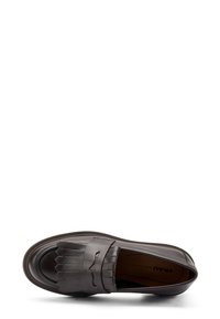 Mocasines de cuero marrón oscuro con lengüeta con flecos y tira para moneda, suela plana y "FRAU Hecho en Italia" visible en el interior.