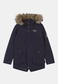 Parka blu navy con cappuccio foderato in pelliccia, dotata di bottoni automatici, due tasche anteriori e un logo sul petto. Texture liscia, design di lunghezza media.