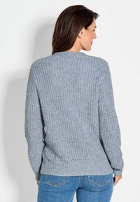 Strickpullover in Hellblau mit strukturiertem Rippenmuster, langen Ärmeln und Rundhalsausschnitt, kombiniert mit Jeans.