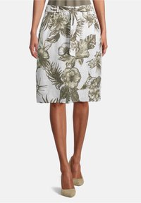 Valkoinen kukkakhame, jossa on vihreitä kasvien kuvioita, solmittava vyötärö ja kevyt kangas rentoon istuvuuteen.