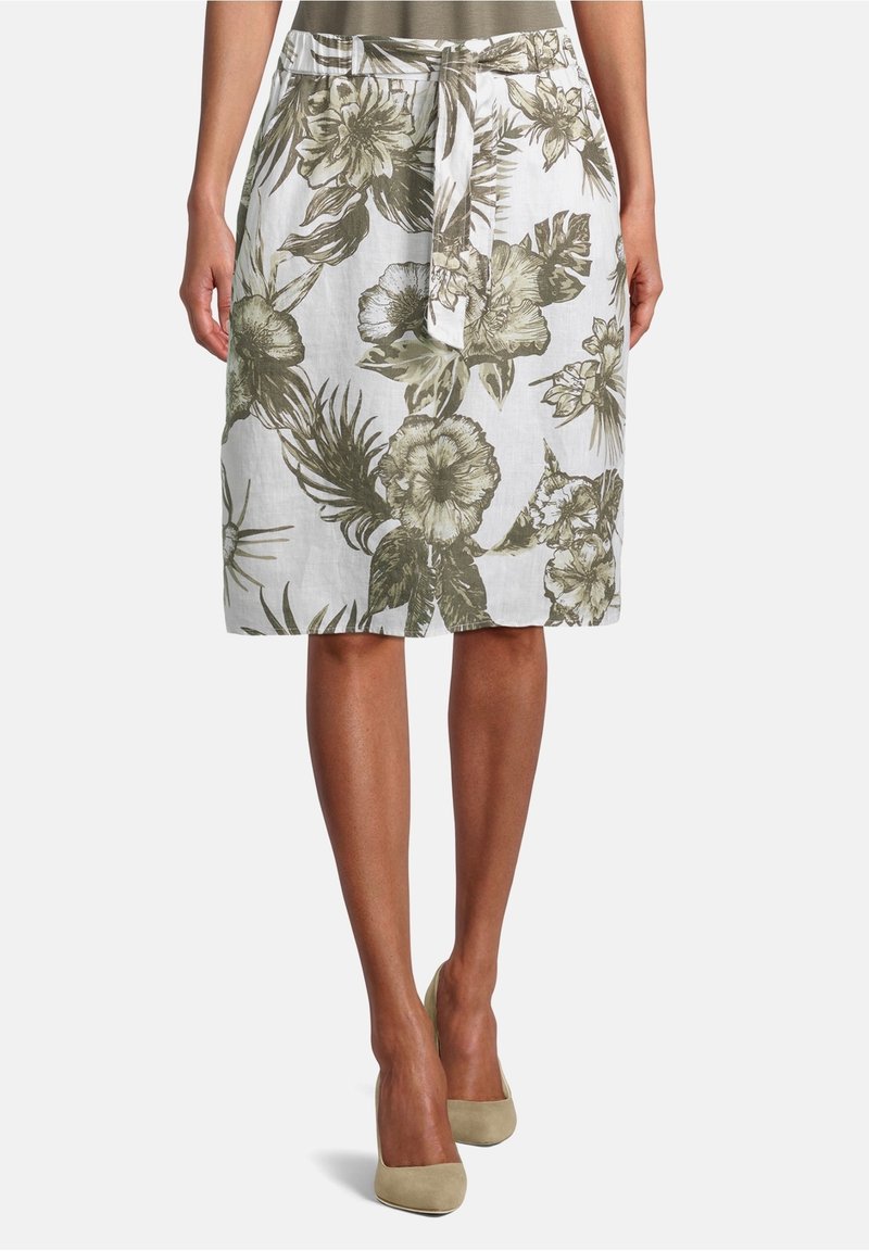 Valkoinen kukkakhame, jossa on vihreitä kasvien kuvioita, solmittava vyötärö ja kevyt kangas rentoon istuvuuteen.