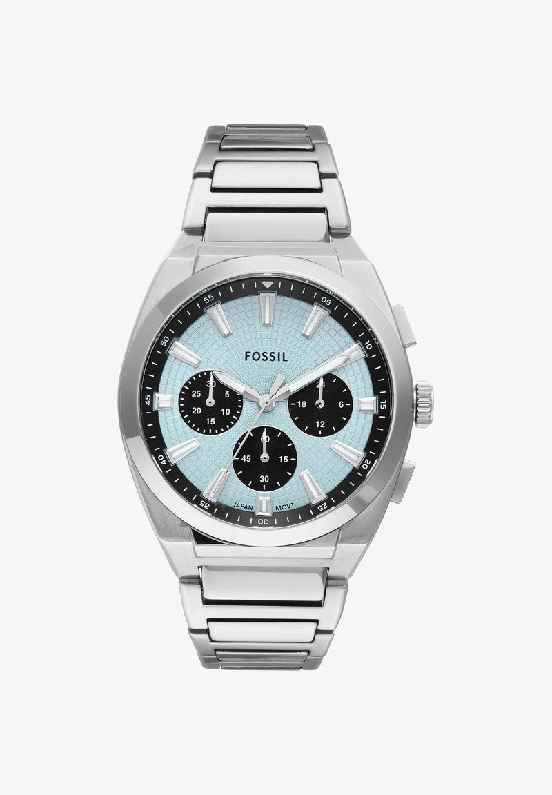 Montre-bracelet Fossil argentée avec cadran texturé bleu clair, trois sous-cadrans noirs, index lumineux et bracelet métallique à maillons.