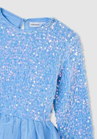 Abito azzurro chiaro con un corpo in paillettes iridescenti e una gonna in tulle. Maniche lunghe e scollo rotondo. Marca: Terranova.