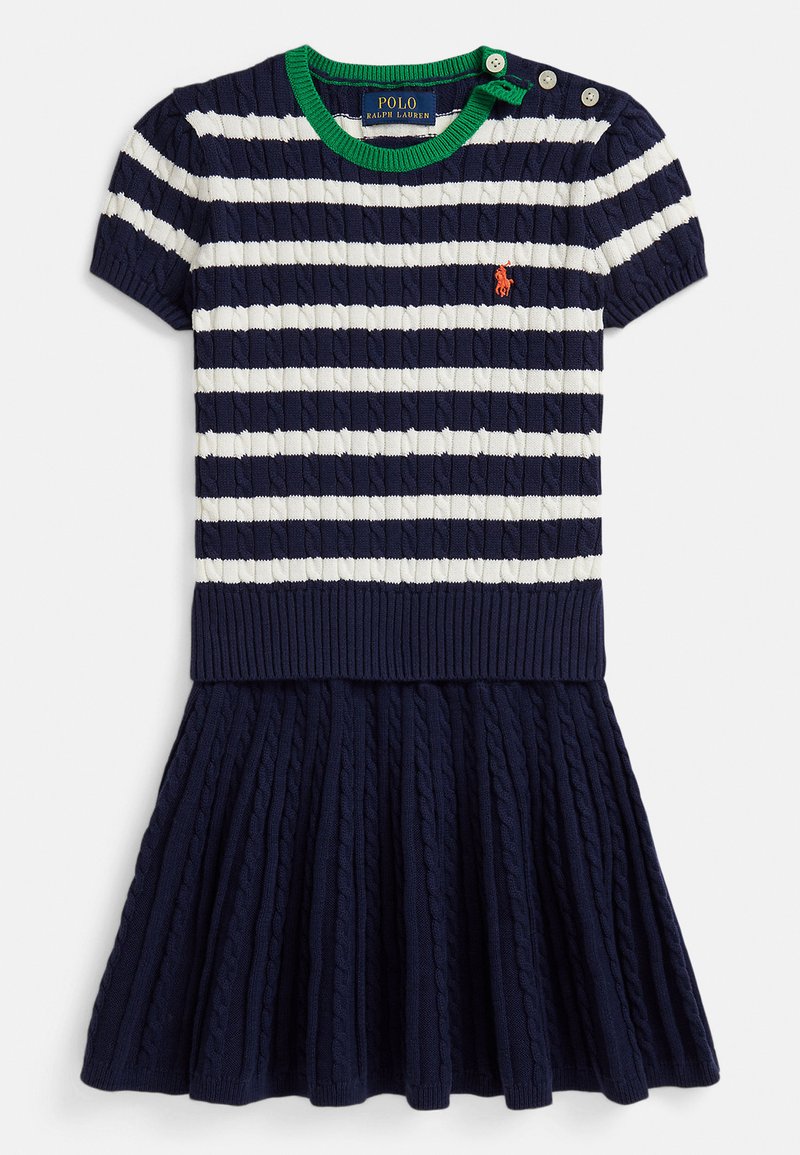 Tmavomodré pletené šaty s bielymi pruhmi, krátkymi rukávmi a zeleným rebrovaným výstrihom. Má plisovanú sukňu a detail s tromi gombíkmi.