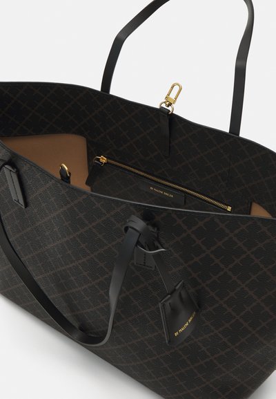Large tote bag in dark patterned material with black leather straps. Features a gold zipper and interior pocket. Smooth texture with geometric design.