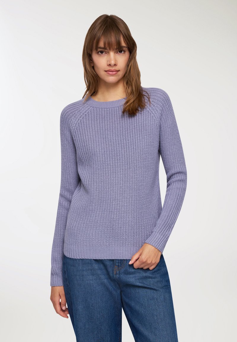 Maglione lavorato a maglia lavanda con motivo testurizzato, polsini a coste e un ampio scollo rotondo, abbinato a jeans a gamba dritta blu.