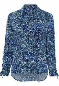 Blouse à manches longues, à motifs bleus et verts, avec un devant à boutons et des accents à nouer aux poignets, fabriquée dans un tissu léger et texturé.