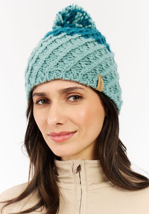 Light blue knitted beanie with a textured diagonal pattern, featuring a pom-pom on top and a brown leather logo tag on the side.