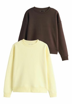 To sweatshirts: den ene i blød gul med en ribbet halsudskæring, den anden i mørkebrun. Begge har droppede skuldre og ribbede manchetter.
