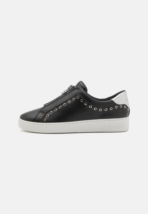 Black leather sneakers with a white rubber sole, side zipper, and metal grommet details. Silver accent at heel with branding.