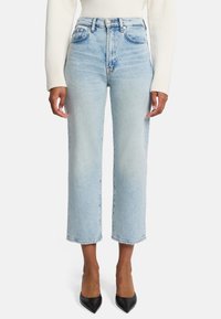 Jeans azzurri a vita alta con design a gamba dritta, cinque tasche e leggero effetto sbiadito. Abbinati a tacchi neri a punta.