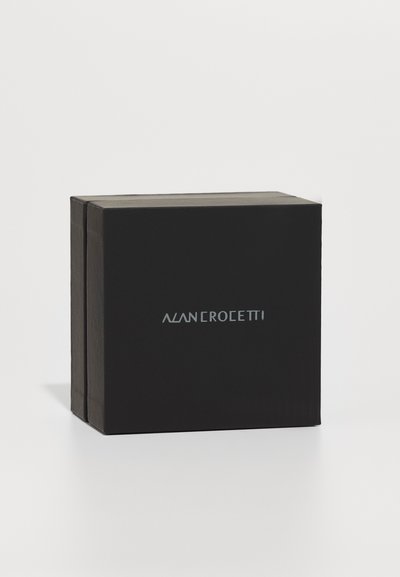 Čierna obdĺžniková škatuľa s matným povrchom, na prednej strane so strieborným logom "ALAN ROEETTI" a otvoreným vrchom. Minimalistický dizajn.