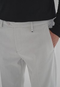 Lichtgrijze corduroy broek met subtiele verticale strepen, voorzien van voorkruippockets en een effen tailleband met een zilveren metalen accent.