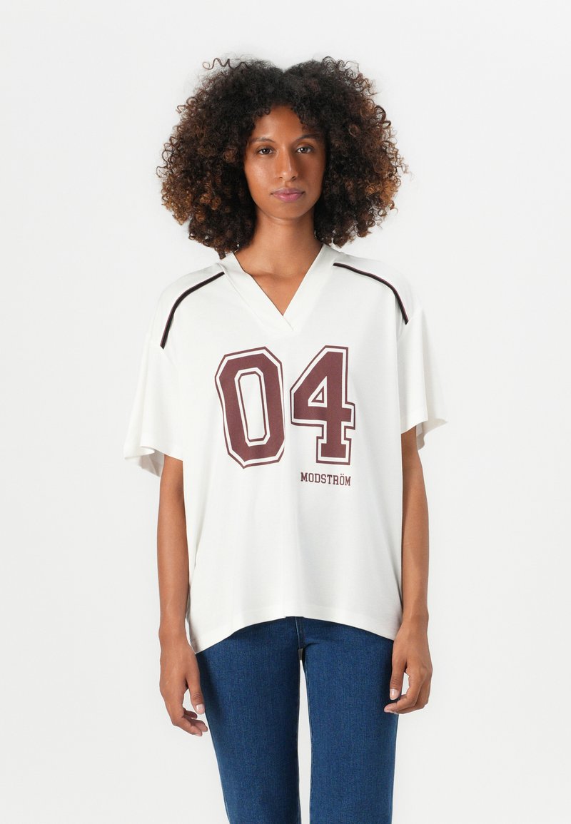 Weißes oversize Jersey mit V-Ausschnitt, kontrastierenden kastanienbraunen Streifen und grafischem "04"-Druck. Weicher Stoff und lockere Passform.