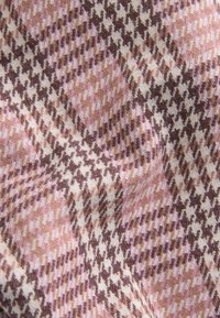 Tessuto intrecciato con un motivo a scacchi in rosa, marrone e crema; texture morbida; presenta un'orientazione diagonale con tonalità variabili.