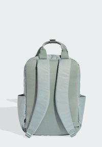 Light teal backpack with a padded mesh back and shoulder straps, featuring a top handle and side pockets for additional storage.