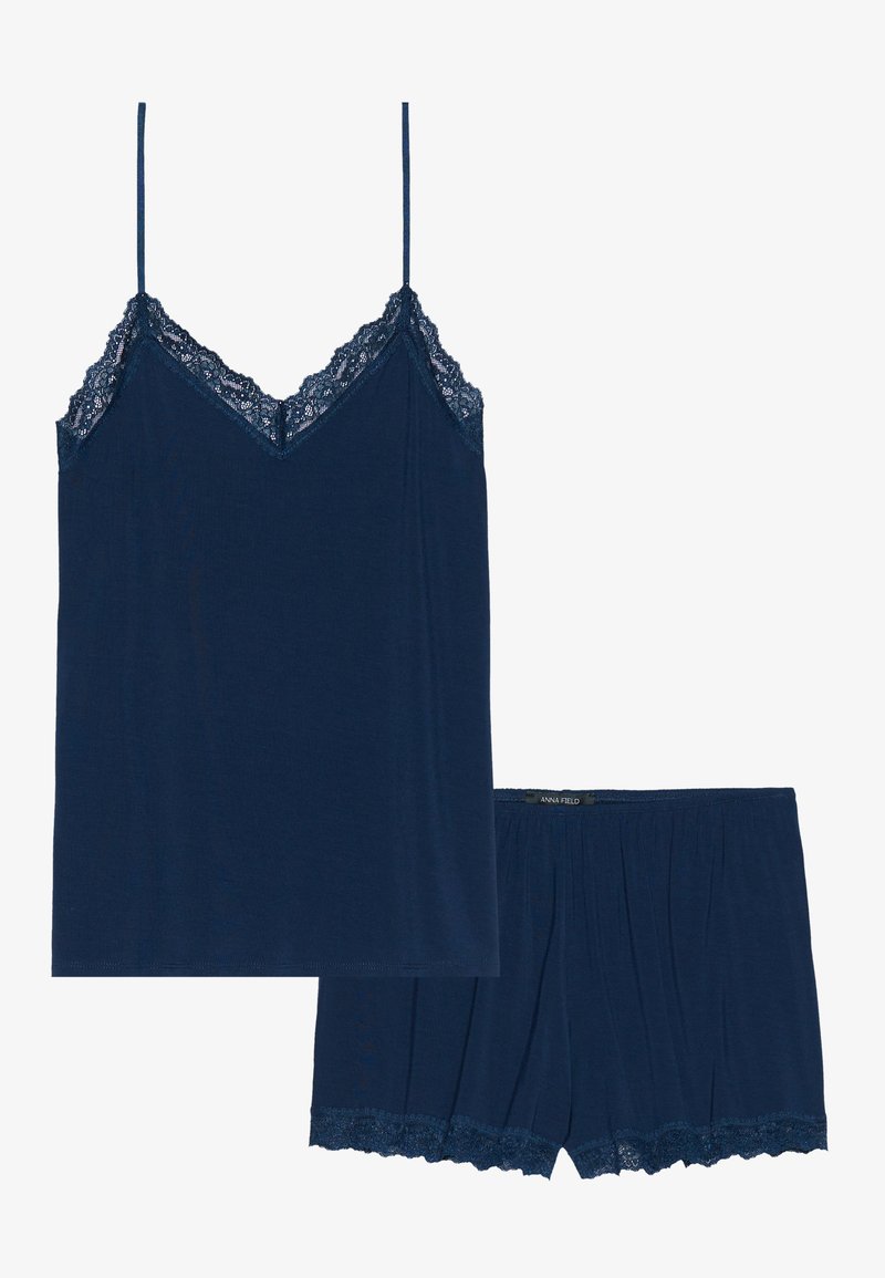 Ensemble débardeur et short bleu marine en tissu doux. Le débardeur présente des bordures en dentelle le long de l'encolure, tandis que le short a des accents en dentelle à l'ourlet.
