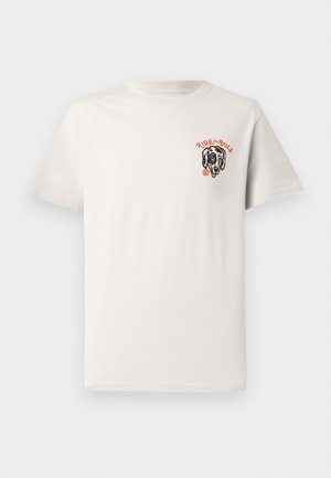 Camiseta de algodón color beige claro con cuello redondo, mangas cortas y un gráfico de un perro negro con el texto "RIDE the RAILS" en color naranja.