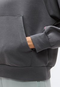 Γκρι φούτερ με τσέπη μπροστά, ριμπ μανσέτες και τελείωμα. Μαλακό υλικό με ομαλή υφή και μινιμαλιστικό σχέδιο.