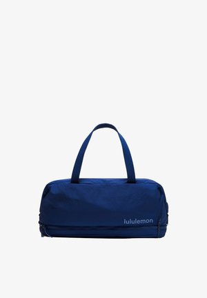Blauer Lululemon-Duffelbag mit zwei Griffen und einem Reißverschlussfach unten vor weißem Hintergrund.
