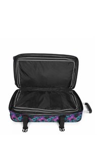 Black interior of a soft-sided suitcase with a colorful floral exterior design, three straps, and a retractable handle, opened for packing.
