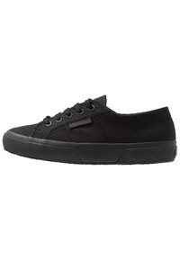 Black canvas sneaker with round toe, textured black rubber sole, six eyelets, and subtle branding on the side. Classic lace-up design.