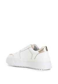 Sneaker bianca in pelle con dettagli metallici oro sul tallone, caratterizzata da un design con lacci, texture liscia e una suola in gomma bianca spessa.