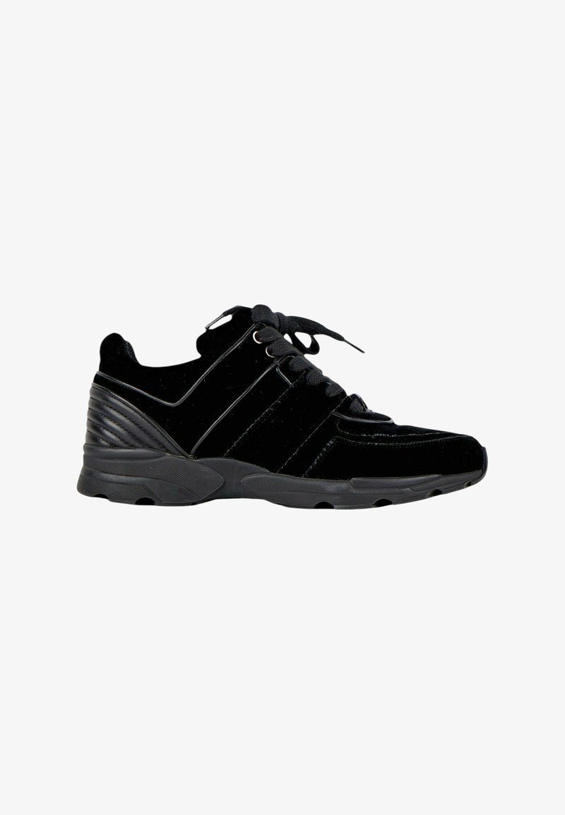 Baskets noires de sport avec fermeture à lacets, semelle épaisse en caoutchouc et contrefort talon texturé, vues de profil sur fond blanc.