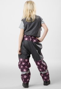 Paarse waterdichte broek met roze sterpatronen, elastische tailleband en grijze accenten, gecombineerd met een grijze T-shirt met korte mouwen.