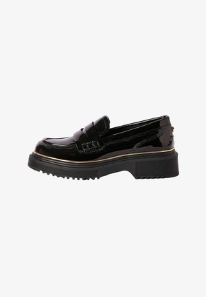Mocasini negri din piele lacuită, cu o platformă joasă, având o bandă decorativă și un accent subtil de aur aproape de talpă. Talpa exterioară este din cauciuc texturat.