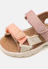 Barnsandaler med tre justerbara textilremmar i persika, rosa och beige, med en strukturerad sula och en gummilogo-accent.