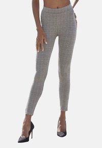 Grau-weiße, karierte High-Waist-Hosen mit schlanker Passform, cropped Länge und glatter Textur. Kombiniert mit schwarzen High Heels.