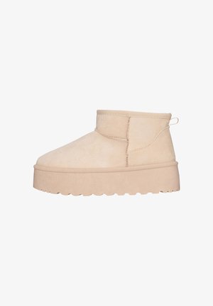 Beige Wildleder-Stiefelette mit runder Zehenpartie, kurzem Schaft und strukturiertem Plateau. Verfügt über einen Zuglasche auf der Rückseite für ein einfaches An- und Ausziehen.