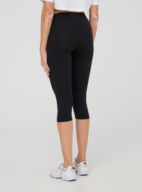 Leggings capri neri con vita alta, realizzati in tessuto elasticizzato, caratterizzati da una texture liscia e una silhouette aderente.