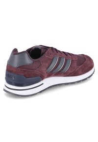 Baskets Adidas en daim bordeaux avec des rayures grises, des panneaux en mesh et une semelle blanche rembourrée, présentées en angle pour montrer le côté extérieur et le talon.