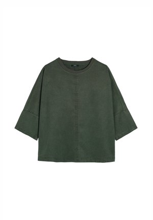 Luźna zielona bluzka z krótkim rękawem, z okrągłym dekoltem, miękką fakturą i pionowym szwem w centralnej części przodu.