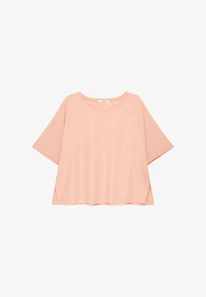 Chemise rose clair, coupe ample, manches courtes, col rond et petites fentes latérales à l’ourlet.