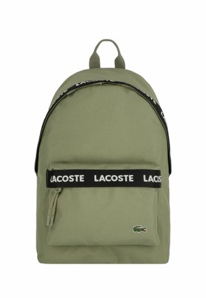 Zaino in tessuto verde con tracolla nera personalizzata, tasca frontale con zip e logo ricamato. Texture liscia e forma arrotondata.