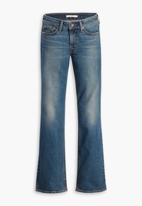 Jean en denim bleu avec légère décoloration, design classique à cinq poches, fermeture par bouton et zipper, et jambes légèrement évasées.