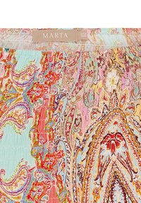 Multifarvet bluse med indviklede paisley- og blomstermønstre i pink, rød og turkis. Blødt, plisseret stof med rund halsudskæring.