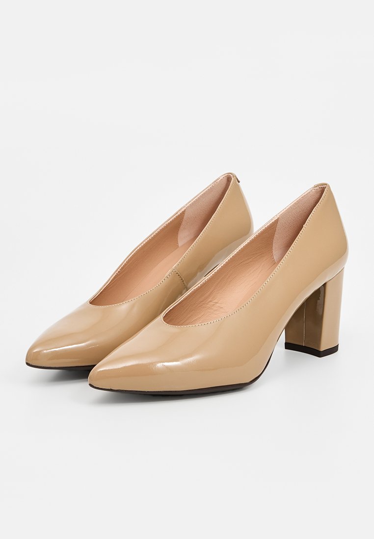 Scarpe con tacco alto in vernice beige, con punta affusolata e tacco a blocco largo. Texture liscia con design minimalista.