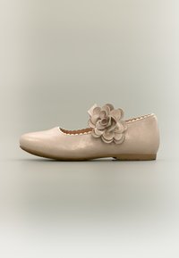 Μπαλαρίνα σε μεταλλικό μπεζ με στρογγυλεμένη μύτη. Διαθέτει διακοσμητικό λουλουδάκι και κυματιστές άκρες κατά μήκος του περιγράμματος.