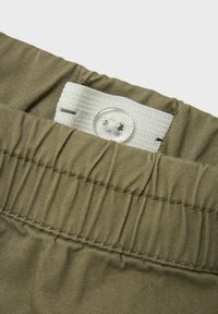 Khaki shorts i tyg med en strukturerad yta, utrustade med ett vitt elastiskt midjeband med knappstängning och samlad sömdetalj.
