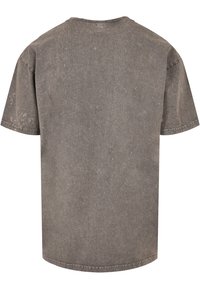 Grå bomulds t-shirt med en tekstureret overflade, korte ærmer, en rund halsudskæring og en afslappet pasform. Slidte detaljer tilføjer visuel interesse.