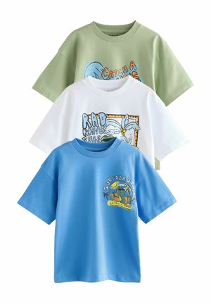 Trois T-shirts à manches courtes : un vert clair avec un graphique de vagues, un blanc avec un design de plage et un bleu avec une illustration de dinosaure. Tous en coton doux.