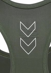 Top atlético de color verde oscuro con diseño de tirantes en la espalda, que presenta acentos gráficos en forma de chevron en blanco, con una textura suave y detalles de costura en contraste.