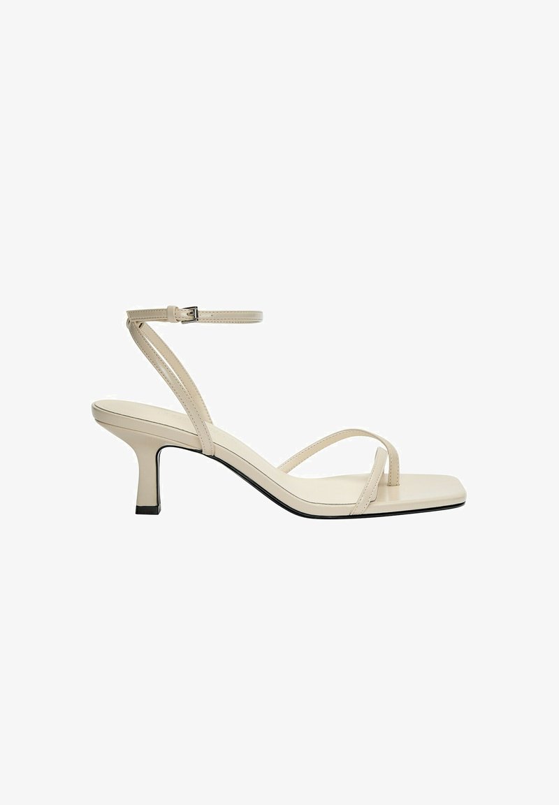 Sandalo beige con cinturini, punta quadrata, cinturino sottile alla caviglia e tacco quadrato di 5 cm. Materiale in pelle liscia con suola nera a contrasto.