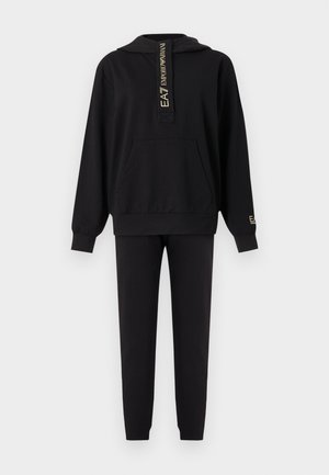 Must EA7 Emporio Armani kapuutsiga dressipluus esitasku ja sobivate mustade dressipükstega, millel kuldsed logotekstid rinnal ja varrukal.